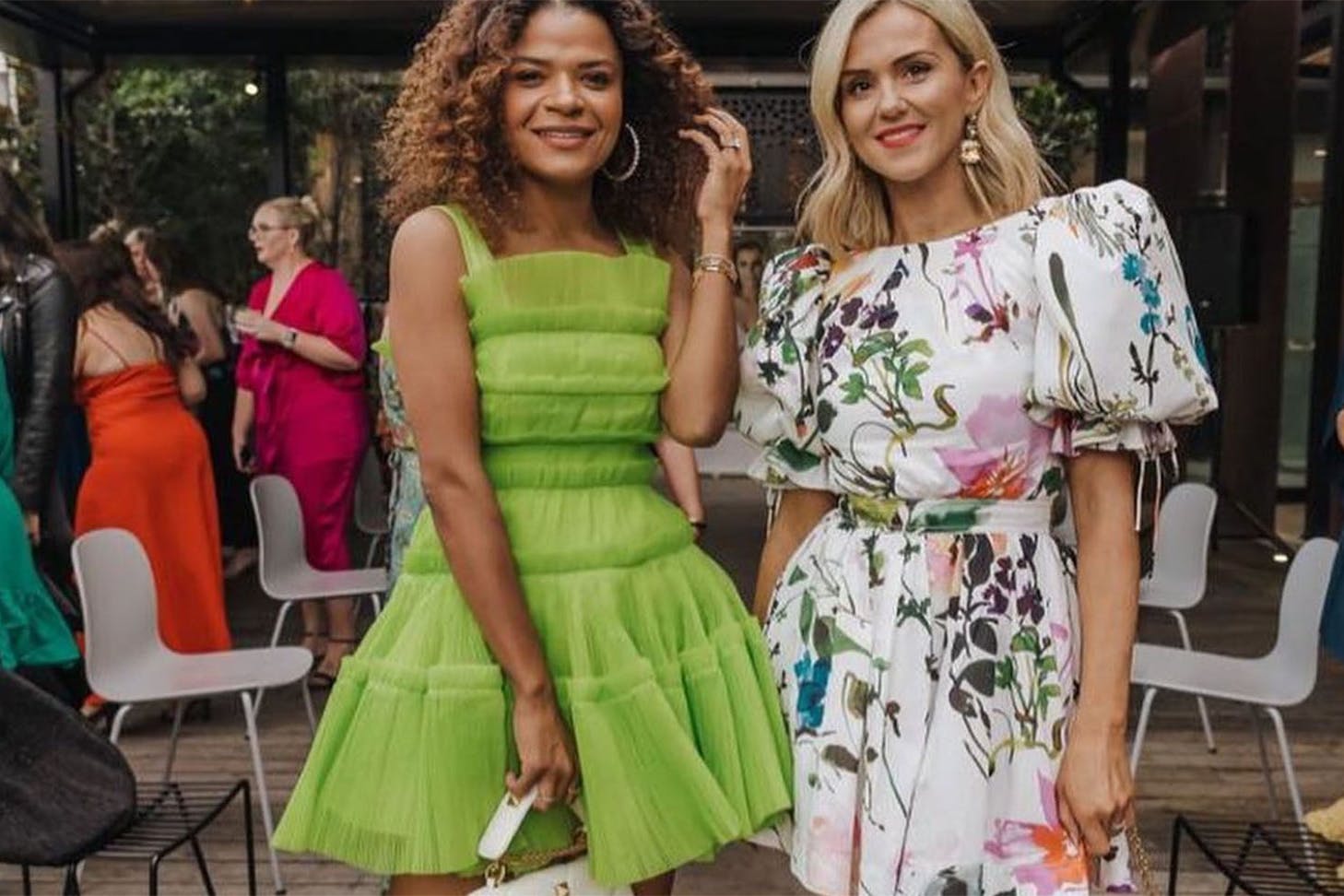 Two women pose in their dresses hired from Treasureboxx, one of the best dress hire shops in NZ.